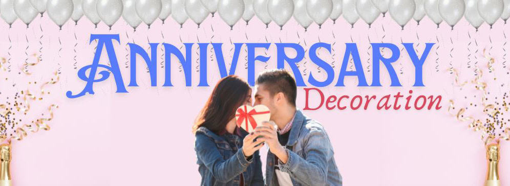 A banner image for "Anniversary Decoration" featuring a romantic couple sharing a moment, holding a heart-shaped gift between them. The background is a soft pink, adorned with silver balloons, golden confetti, and two champagne bottles at the bottom corners.