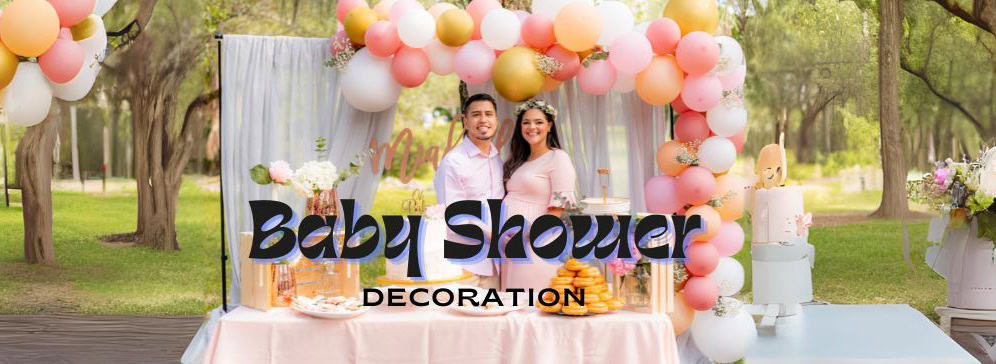 A banner image for "Baby Shower Decoration" showing a joyful couple standing in front of a beautifully decorated baby shower dessert table outdoors. The table is adorned with a pink tablecloth, cakes, and pastries, beneath a balloon arch with pink, white, and gold balloons. Lush green trees are visible in the background.