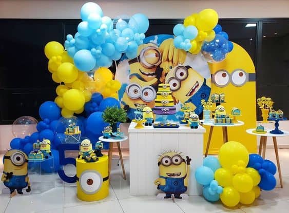 Minion theme birthday decoration in Gurgaon with yellow and blue balloons, custom Minion backdrop, cake table, and character cutouts by Adore Celebration.
