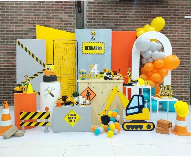 A detailed construction theme birthday party setup by a Party Decorator in NCR, featuring a yellow excavator cutout and a personalized "BERNARDO" sign. This example of Kids Birthday Decoration in Gurgaon includes balloon garlands, a tiered cake, and toy trucks, showcasing high-quality Customized Birthday Decor in NCR.